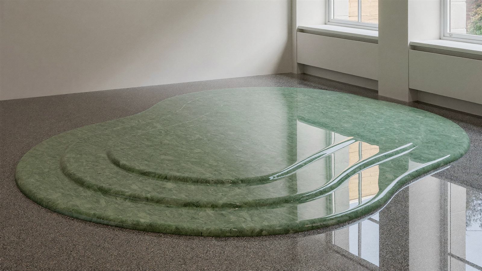 Glänzend polierter Designestrich-Boden in salbeigrünen und anthrazitfarbenen Terrazzo-Tönen in einer modernen Musterausstellung