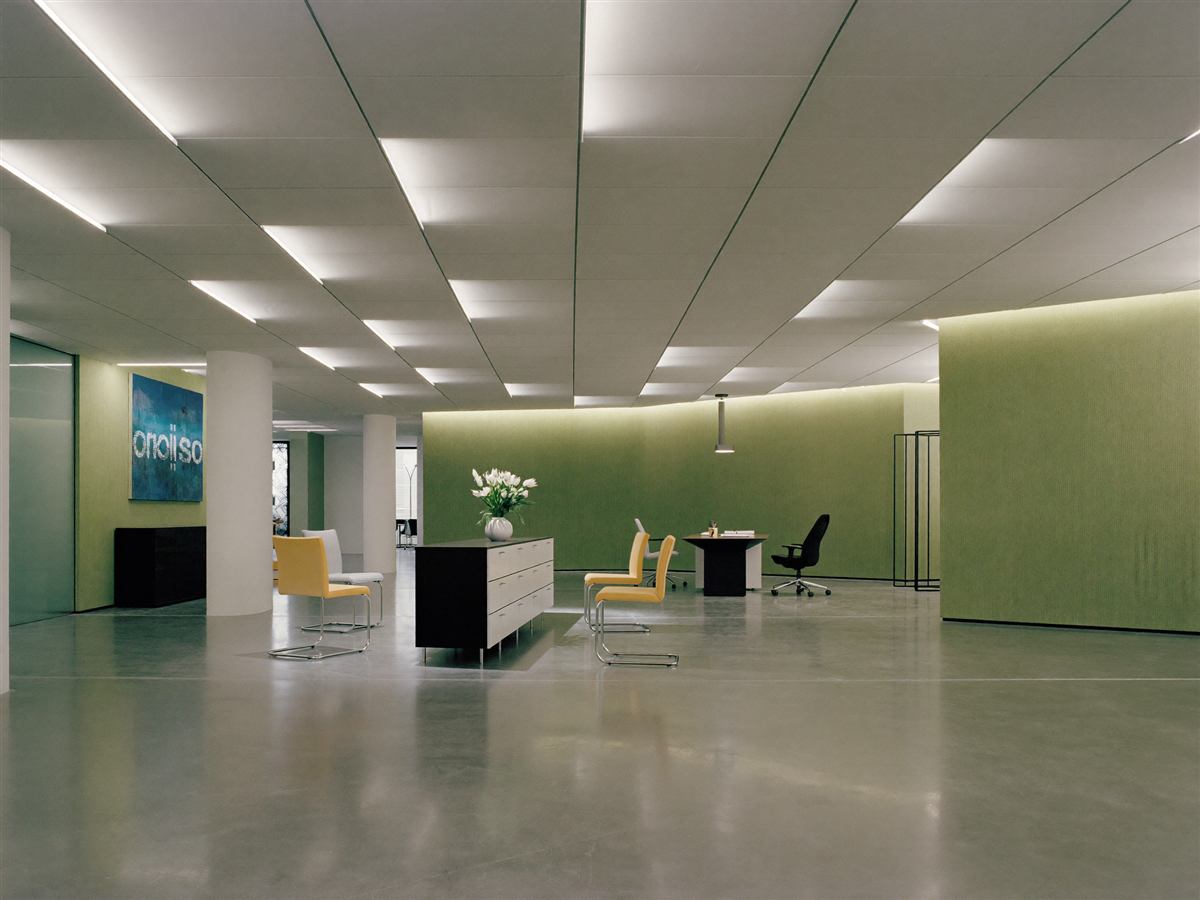 Fertiggestellte moderne Bürolobby mit glänzend poliertem Betonboden, der die Deckenbeleuchtung reflektiert